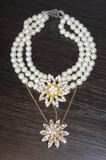 Пластиковое, многослойное колье с двумя подвесками в форме цветов.