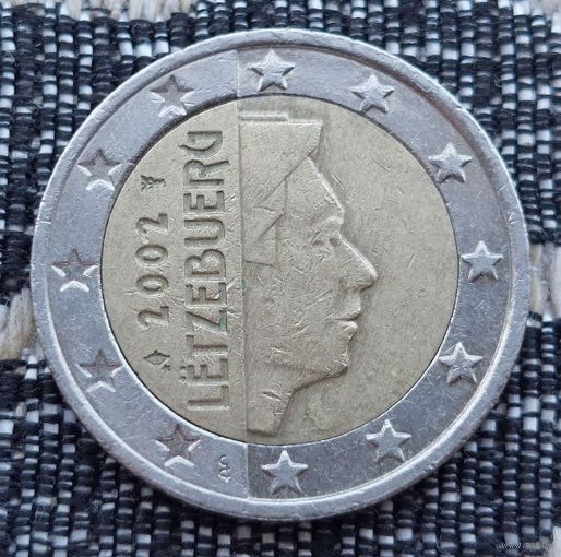 Люксембург 2 евро 2002 года. Король. Клеймо Гастауер-Клер Иветта. Лук со стрелой и звёздочкой и Посох Меркурия.